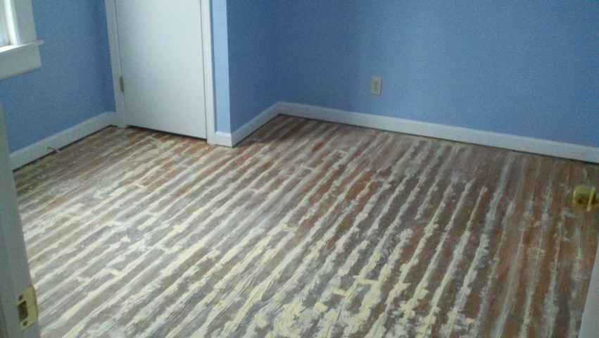 A hardwood floor showing major scratches and serious scuffs.